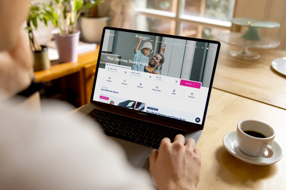 Viewing East Midlands Airport website on a laptop in a coffee shop